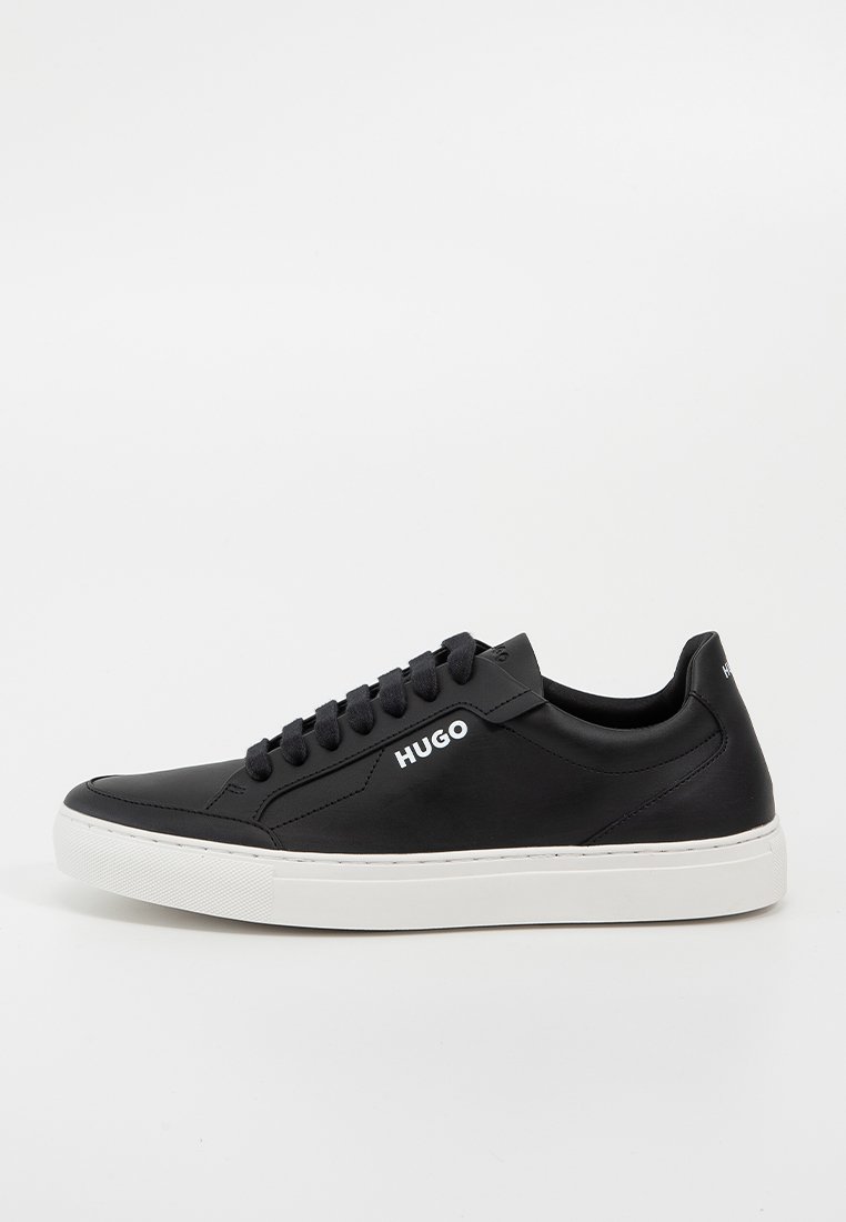 Schwarzer Low-Top-Sneaker mit weißer Sohle, schwarzen Schnürsenkeln und "HUGO"-Logo an der Seite und am Fersenbereich, schräg links auf weißem Hintergrund.