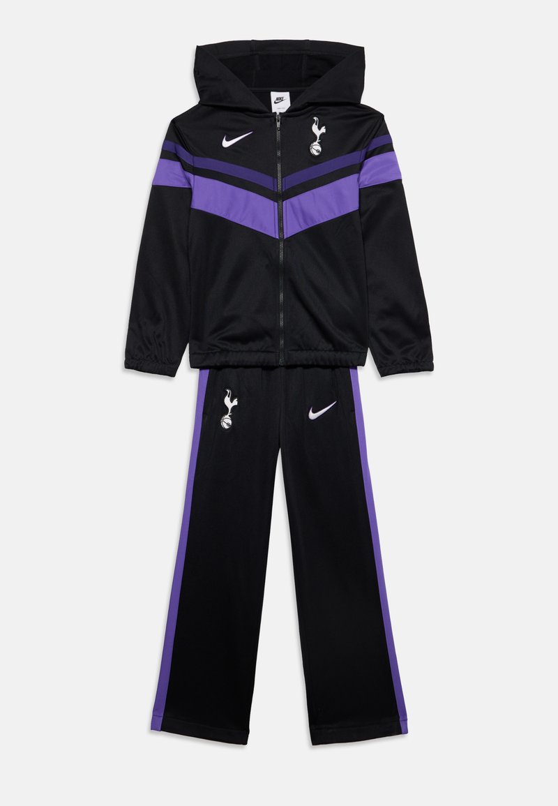 Μαύρο και μωβ φόρμα Nike με φούτερ με κουκούλα και φερμουάρ και παντελόνι, με λογότυπα της ποδοσφαιρικής ομάδας Tottenham Hotspur στο φούτερ και στο παντελόνι.
