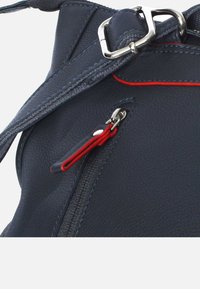 Marine leren handtas met een gestructureerd oppervlak, voorzien van een zilveren metalen gesp, rode ritsaccenten en contrasterende stiksels.