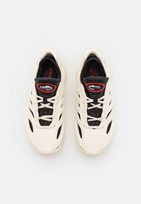 Beige athletic shoes with a textured black mesh upper, features prominent airflow vents, and a red "CLIMACOOL" logo on the tongue.