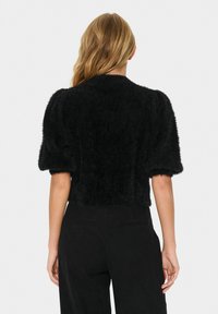 Zwarte cropped bontjas met korte pofmouwen en een gestructureerd oppervlak. Kenmerkt een geribbelde onderrand en geen zichtbare sluitingen.