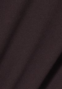 Tissu tricoté brun foncé, présentant une texture fine avec une sensation douce, légèrement élastique et un motif subtil et régulier.