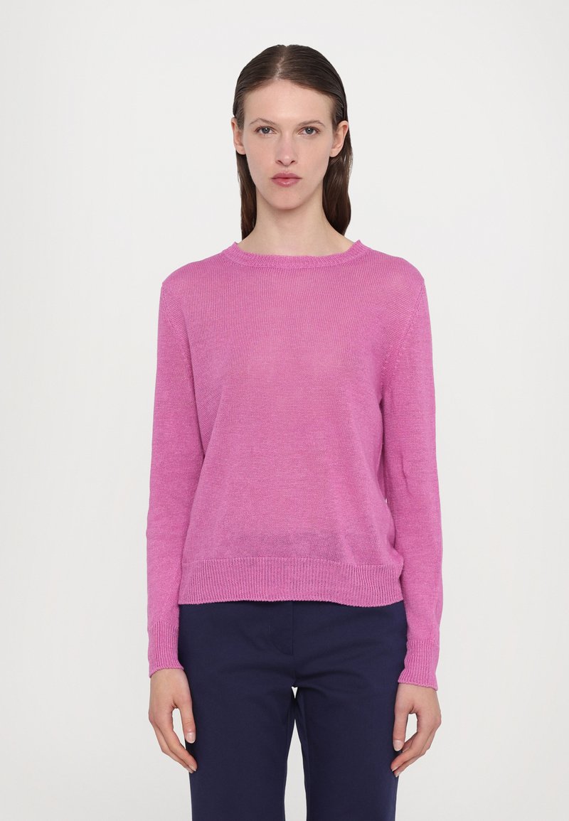 Pullover rosa a maglia con maniche lunghe, scollatura rotonda, orlo a coste e vestibilità rilassata, abbinato a pantaloni blu navy. Tessuto morbido e design leggero.