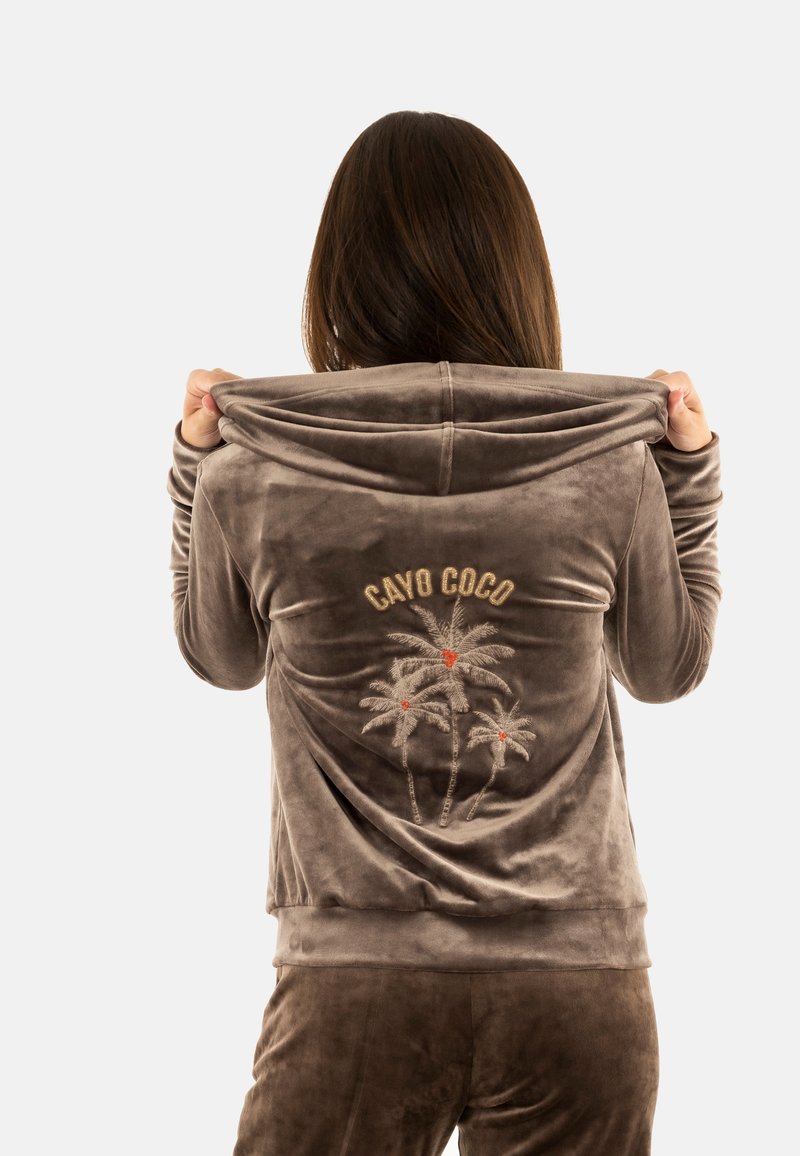 Hoodie in velluto marrone con ricamo "CAYO COCO" e design di palme. Presenta un cappuccio con cordino e una texture morbida e liscia.
