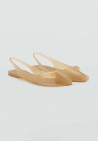 Transparent tan slingback sandals with a rounded toe and cut-out design. Made of smooth plastic, featuring a flat sole and minimal detailing.
