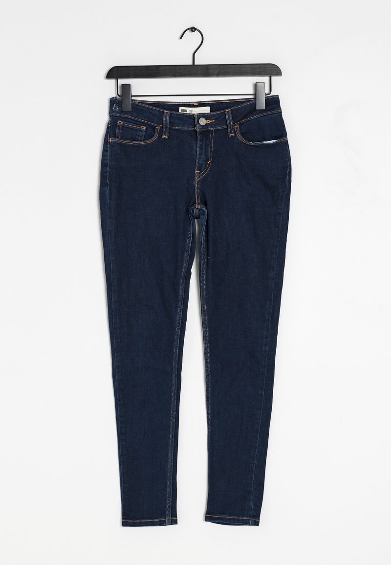 Smala mörkblå jeans i denim, med fem fickor, synlig sömnad i en kontrasterande orange färg och en standard midja.