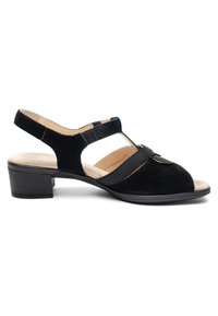 Sandalia baja de tacón en ante negro con tira trasera, puntera abierta y detalle de tira en T elástica sobre una plantilla beige.