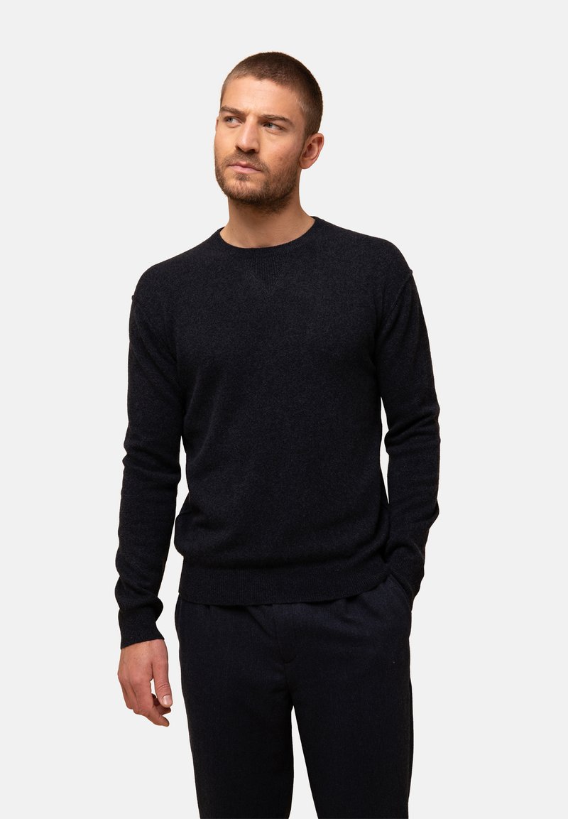 Dunkelblaues Crew-Neck-Pullover aus weichem Strickstoff, mit langen Ärmeln, gerippten Bündchen und einem taillierten unteren Saum. Strukturiertes Oberflächendesign.