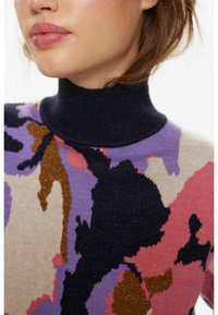 Megztinis su aukšta tamsiai mėlyna apykakle. Savybė – daugiaspalvis abstraktus raštas rožinės, violetinės, juodos ir auksinės spalvų akcentais.