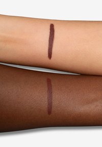 Due braccia con una linea tracciata, quella superiore di tono della pelle chiara e quella inferiore di tono della pelle scura, entrambe mostrano un colore rosso-bruno intenso.
