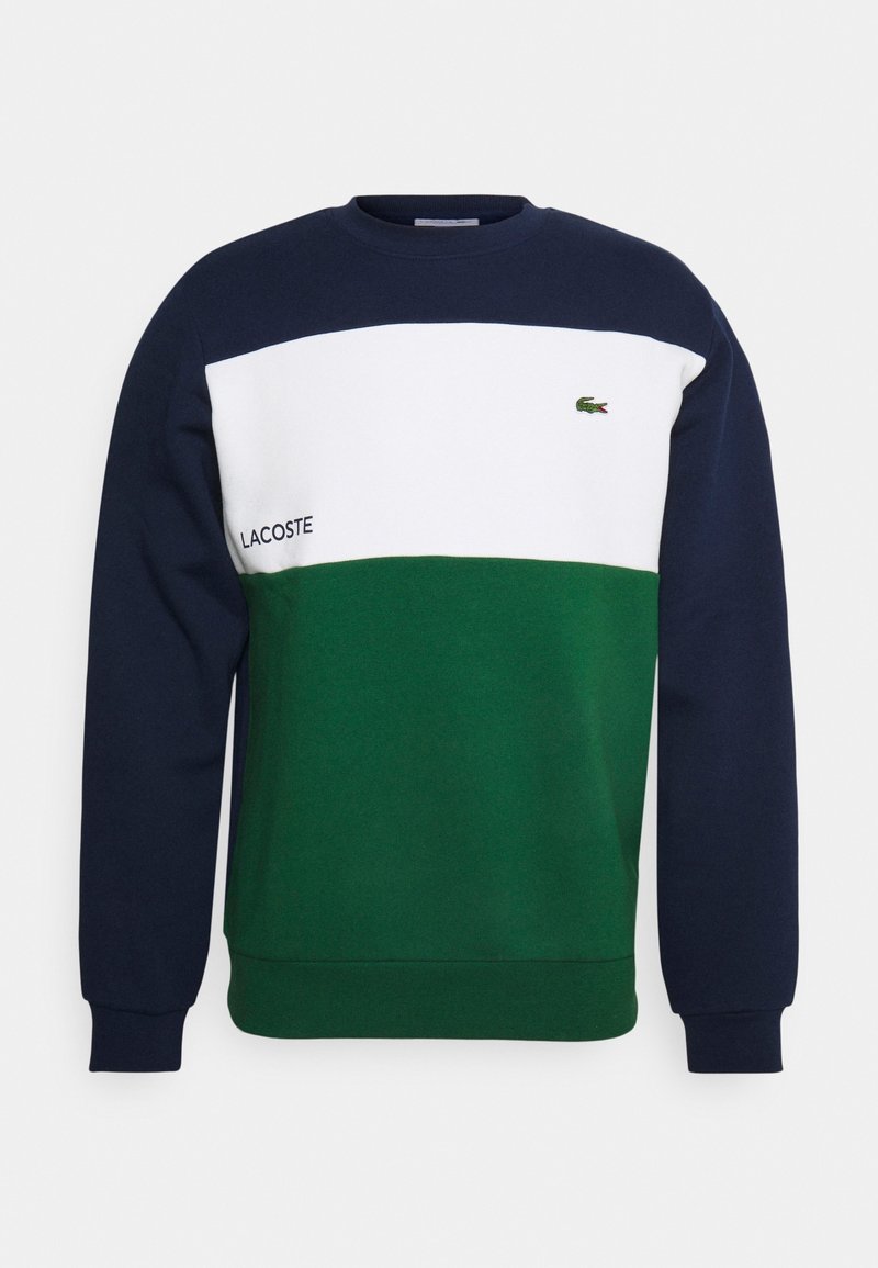 Sweat-shirt à blocs de couleurs bleu marine, blanc et vert avec logo Lacoste et emblème du crocodile sur la poitrine, manches longues et col rond.