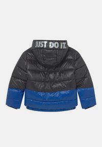 Czarna i niebieska kurtka puchowa, z kapturem, z poziomym wzorem kolorowym, błyszczącą teksturą i napisem "JUST DO IT." nadrukowanym na kołnierzu.