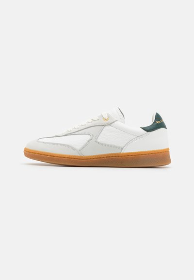 White sneaker with a smooth leather upper, grey accents, gold eyelets, and a gum rubber sole. Green logo on the heel. Low-profile design.