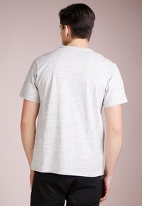 T-shirt grigio mélange a maniche corte con collo rotondo, vestibilità rilassata e una texture liscia con sottili motivi a puntini.