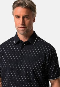 Černé polo tričko s opakujícím se vzorem přesýpacích hodin v bílé a světle modré barvě, s kontrastním límcem a zapínáním na tři knoflíky.