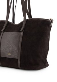 Schwarze Wildleder-Handtasche mit einem strukturierten dunkelbraunen Lederpaneel. Verfügt über zwei Trageriemen und einen Reißverschluss. Dezente goldene Markenprägung auf der Vorderseite.