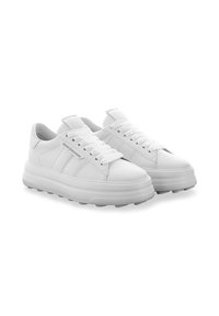 Een paar witte lage sneakers met plateauzolen, dikkere zolen, veters en een subtiel merkembleem aan de zijkant, afgebeeld tegen een witte achtergrond.