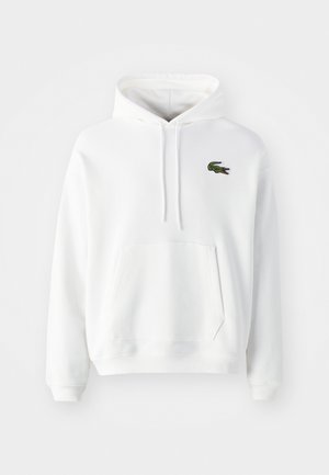Weiße Kapuzenjacke aus weichem, strukturiertem Stoff. Verfügt über eine Kängurutasche und ein grünes gesticktes Krokodil-Logo auf der linken Brust. Kapuze mit Zugband.