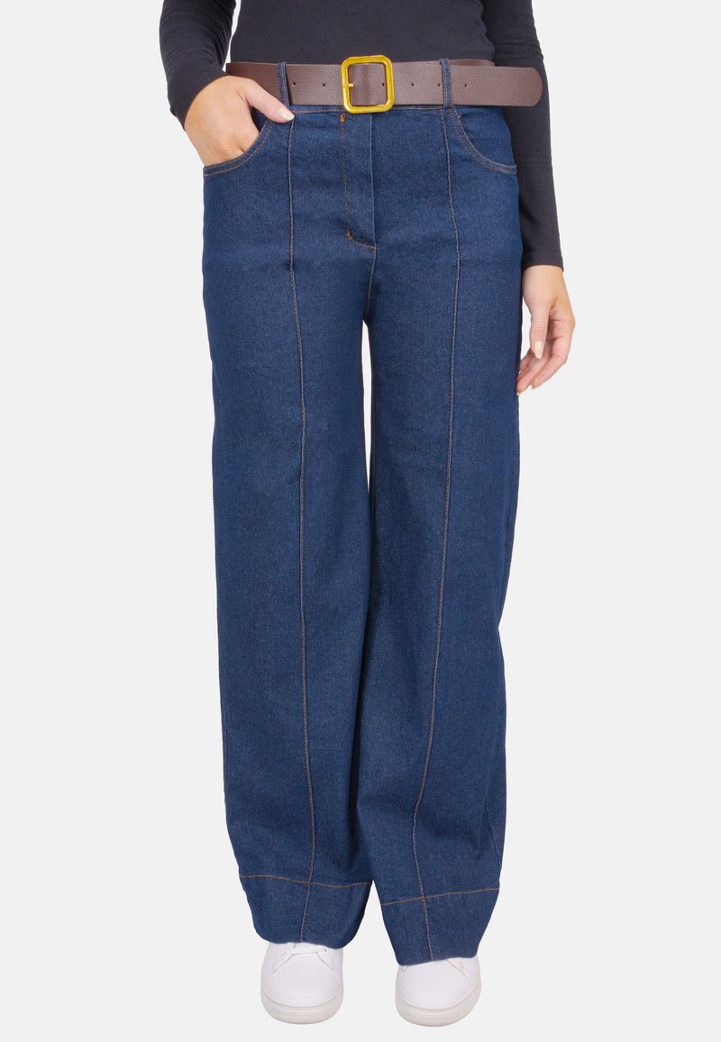 Pantalon large en denim bleu avec surpiqûres orange, taille haute et deux poches latérales. Associé à une ceinture marron avec une boucle carrée jaune.