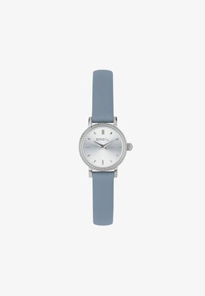 Montre argentée avec cadran rond, fond blanc, marquages argentés, lunette texturée et bracelet en cuir bleu pâle. Design compact, style minimaliste.