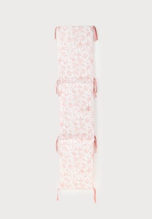 Long coussin en tissu floral rose et blanc avec attaches, divisé en trois sections rembourrées pour siège de chaise ou de banc.