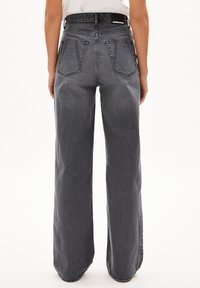Grå vida jeans med hög midja, som har två bakfickor och kontrasterande sömmar. Tillverkade av denim med en slät textur.