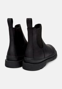 Bottes Chelsea en cuir noir dotées de panneaux latéraux élastiques, de languettes de tirage et d'une épaisse semelle en caoutchouc avec un motif texturé.