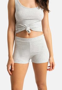 Débardeur côtelé gris clair avec un détail de nœud à l'avant, associé à un short taille haute assorti, le tout en tissu doux et extensible.