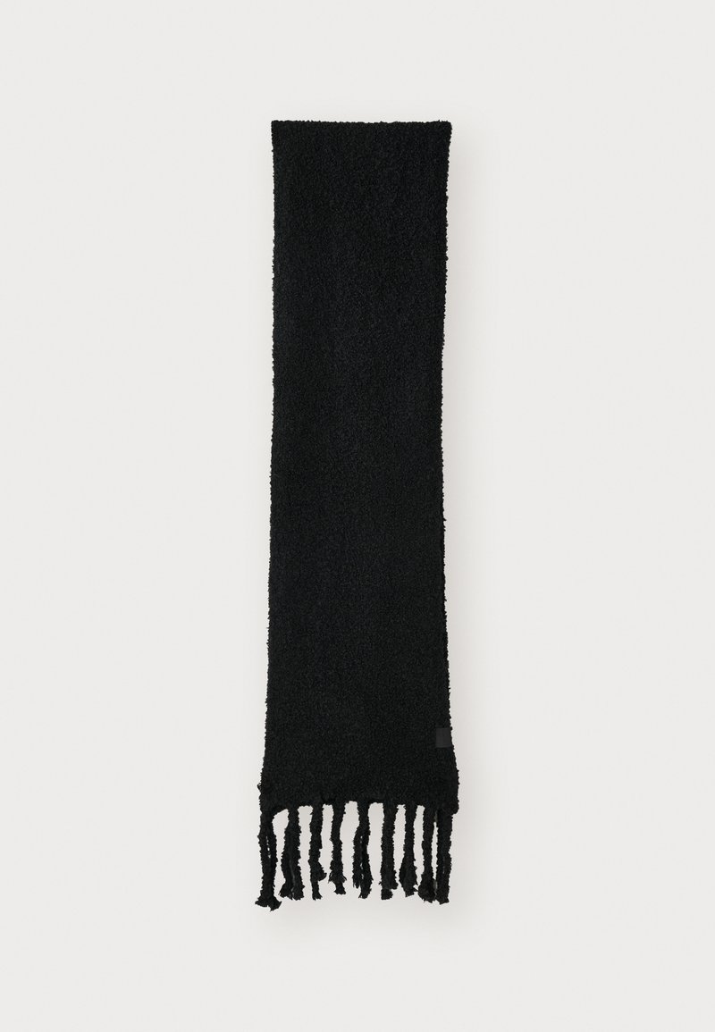 Écharpe noire texturée avec des extrémités effilochées, fabriquée dans un matériau doux. Forme longue et rectangulaire, avec un design simple et uni.