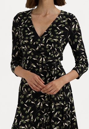 Black wrap dress with green and beige leaf patterns, three-quarter sleeves, and a tied waist belt, shown from neck to mid-thigh.