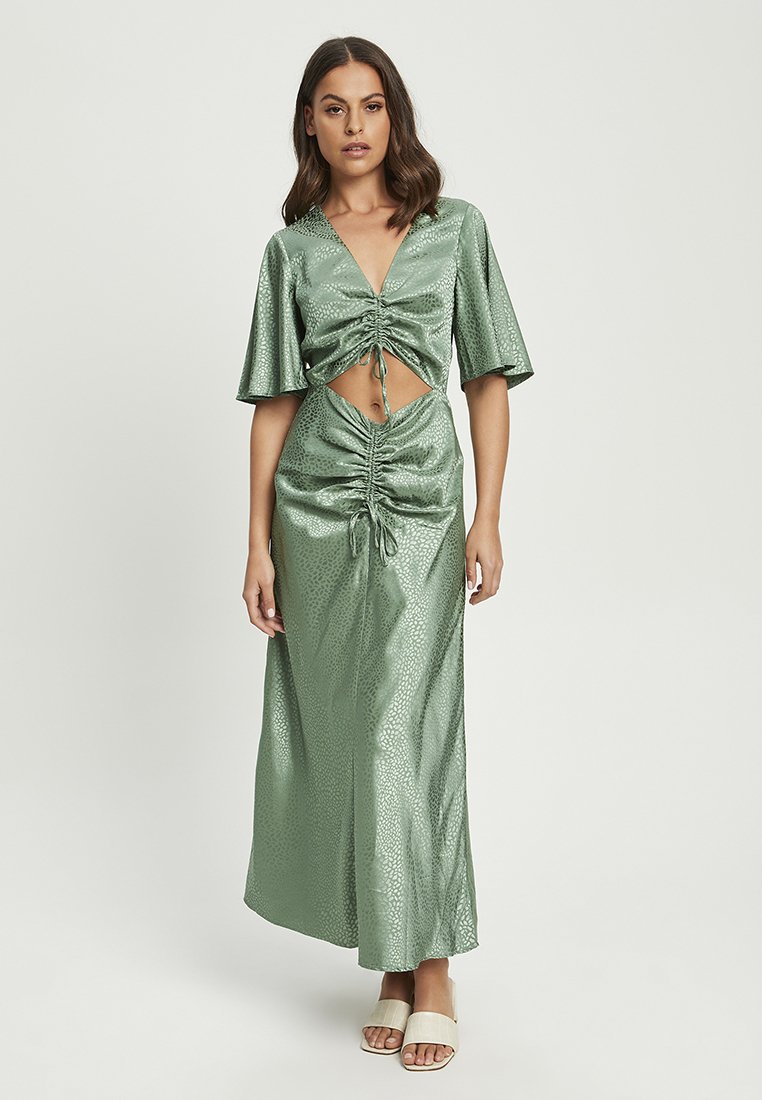 Grünes Satin-Kleid mit V-Ausschnitt, schwingenden Ärmeln und einem Front-Ausschnitt. Mit gerafften Details und einem bodenlangen Rock.