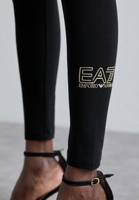 EA7 Emporio Armani Κολάν - Παντελόνια - black/gold-coloured