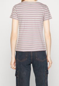 Stribet t-shirt i lys grå med vandrette linjer i rød og lilla. Korte ærmer, rund halsudskæring, blød tekstur, afslappet pasform.