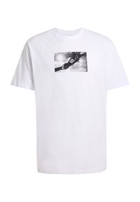 Λευκό βαμβακερό μπλουζάκι με μαύρο και άσπρο γραφικό τύπωμα παπουτσιού. Το σχέδιο απεικονίζει σύννεφα και έναν ήλιο στο φόντο.