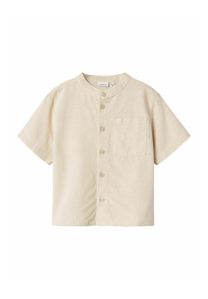 Camicia a maniche corte, di un leggero color beige, con colletto rotondo, taschino sul petto e cinque bottoni sul davanti. Tessuto con texture liscia.