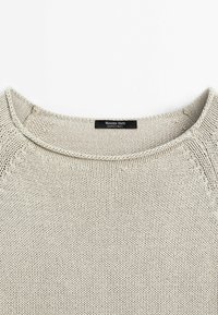 Lichtbeige gebreid sweater met een ronde halslijn, open weefstructuur en zichtbare stikdetails. Het label geeft "Massimo Dutti" aan.