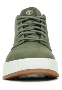 Green suede sneaker with a white textured rubber sole and tan accents. Features round laces and a logo on the tongue.