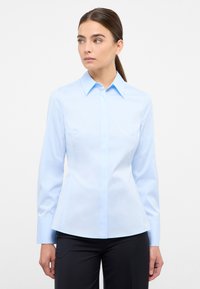Light blue button-up shirt with a classic collar, long sleeves, and a fitted design. Made of smooth fabric; no visible patterns or accents.