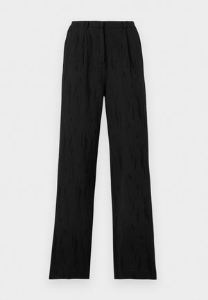 Zwarte hoge taille wijde broek met plooien en een voorste tailleband tegen een effen lichte achtergrond.