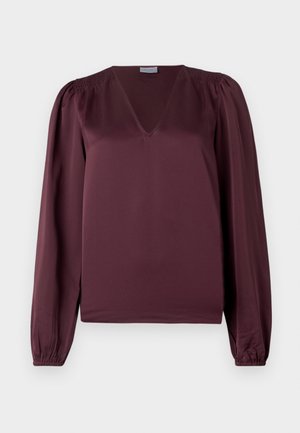 Bordeaux blouse met een V-hals, lange pofmouwen en smockdetails op de schouders. Gemaakt van een gladde, lichte stof.