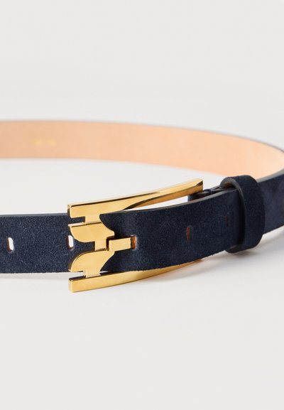 Ζώνη από μπλε σουέντ με χρυσή μεταλλική αγκράφα σε ορθογώνιο σχήμα και ταίριαστο λουράκι από σουέντ, παρουσιάζεται τυλιγμένη σε λευκό φόντο.