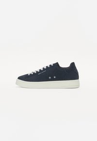 Marineblå ankel sneaker i semsket skinn med hvit gummisåle, rund t�å og snøring foran. Har minimal merking og to dekorative hull på siden.