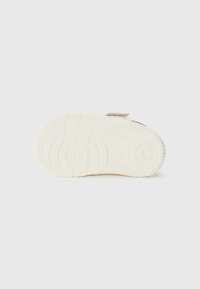 Suola della scarpa realizzata in un materiale gommoso testurizzato di colore bianco sporco. I motivi circolari e lineari offrono aderenza e trazione.