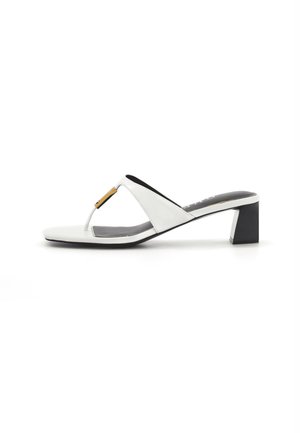 Sandale à talon en cuir blanc pour femme avec talon noir épais et accent doré sur la bride avant, vue de profil sur fond blanc.