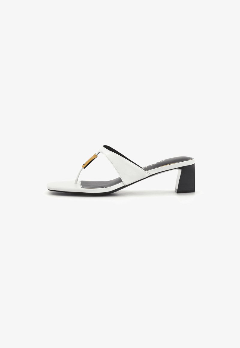 Sandale à talon en cuir blanc pour femme avec talon noir épais et accent doré sur la bride avant, vue de profil sur fond blanc.