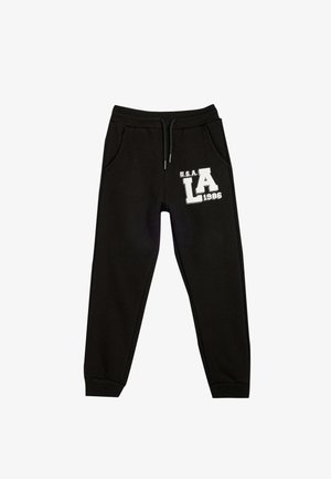 Zwarte joggingbroek met elastische tailleband en trekkoord. Bevat zijzakken en een witte grafische print met de tekst "U.S.A. LA 1986." Zacht van textuur.