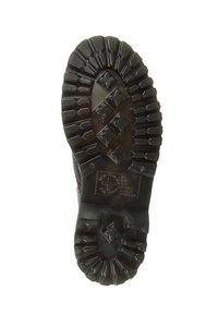 Czarna gumowa podeszwa buta z głębokimi wzorami bieżnika, z wielokierunkowymi wypustkami zapewniającymi przyczepność oraz gładką centralną częścią.