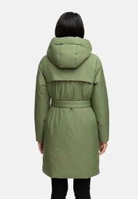 Olivengrøn polstret frakke med stor hætte, bælte i taljen og klapdetalje over ryggen, der har en glat, mat stof tekstur.