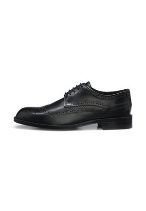 Schwarzer Herrenschuh im Oxford-Stil aus Leder mit Brogue-Details und geschlossenem Schnürsystem, von der Außenseite vor weißem Hintergrund gezeigt.