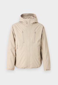 Beige vedenkestävä takki hupulla, jossa on kaksi vetoketjullista rintataskua ja suora malli. Pehmeä pinta, säädettävät hihansuut.